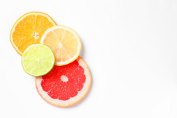 Slices of fresh ripe citrus fruits on white background, flat lay. Space for text