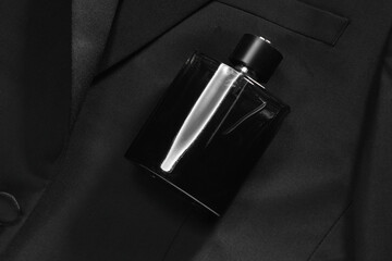 Luxury men's perfume in bottle on black jacket, top view