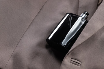 Luxury men's perfume in bottle on beige jacket, space for text