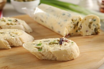 Tasty butter with olives, green onion, chili pepper and bread on table, closeup