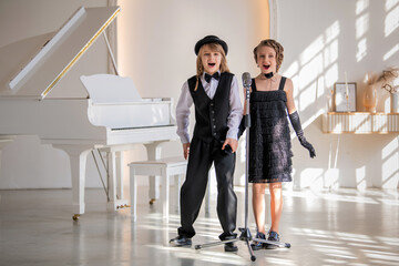 Two young children in formal wear sing a duet into a microphone.