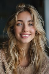 Fototapeta premium This image of a young woman with long, wavy blonde hair. She has light blue eyes and is smiling.