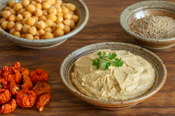 Homemade dip with chickpea, sesame seeds, and Ethiopian eggplant. On the side are the main ingredients: cooked chickpea, unshelled sesame seeds, and dried Ethiopian eggplant — healthy vegan food.