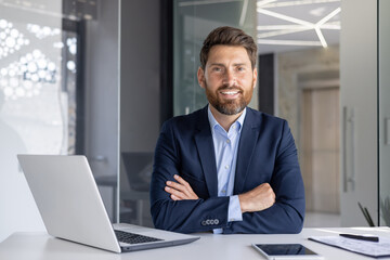 Confident businessman smiling at modern office desk