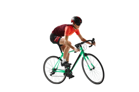 Muscular young man, athlete, cyclist in uniform and helmet, riding bicycle against transparent background. Concept of sport, action, competition, power and endurance, healthy lifestyle.