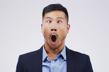 Businessman, crazy and wow face in studio for emoji, comedy and fun by white background. Asian male...