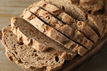 Freshly baked cut sourdough bread on wooden table, closeup