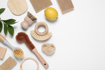 Cleaning brushes, lemon, baking soda, sponges and leaves on white background, flat lay. Space for text