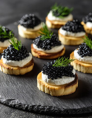 Close-up of canapes with cream cheese and black caviar. Delicious snack. Tasty delicacy.