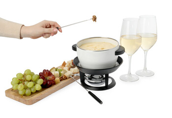 Woman holding fork with walnut above fondue pot with melted cheese on white background, closeup