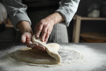 Woman making pizza dough at table, closeup