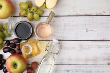 Different types of vinegar and ingredients on wooden table, flat lay. Space for text