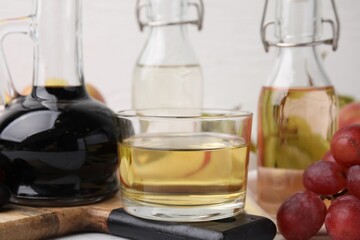 Different types of vinegar and grapes on table