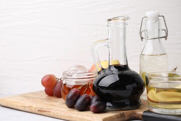 Different types of vinegar and grapes on table