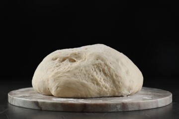 Raw homemade dough on black table, closeup