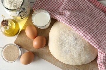 Raw dough and ingredients on white wooden table, top view