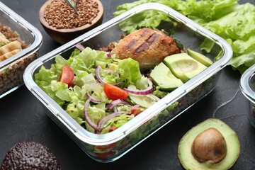 Healthy meal. Fresh salad, avocado, cutlet and buckwheat in glass container near other products on...