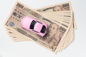 事故でボディーが変形したミニカーとお金
