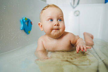 Adorable of asian newborn baby bathing in bathtub.mother bathing her son in warm water.Happy...