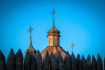 Zaporizhzhya Sich - chapel with three crosses on its facade stands behind a wooden fence under a...