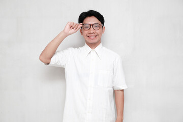 Portrait of Asian man looking at camera while holding his glasses isolated on white background