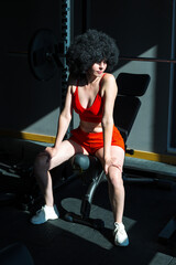 Portrait of a sexy brunette girl gym with black curly hair