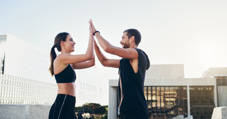 Man, woman and high five for fitness in city, workout and exercise with partnership for training. Friends, teamwork and male personal trainer outdoor for wellness, success and teamwork in New York