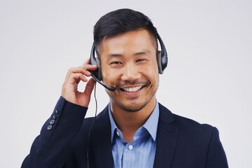 Asian man, thinking and call center in studio with smile, headset and happy on white background....