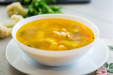 Homemade chicken vegetable soup on rustic wooden background