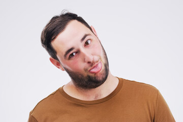 Studio, portrait and man with tongue out, comic and goofy expression with mockup space. Face, male model and comedy or funny with silly reaction, emoji and crazy with backdrop by white background