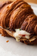 Close-Up of a Croissant Sandwich Packed with Ham and Melted Cheese - Breakfast Treat Close Up