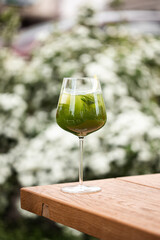 Fresh Mojito and Summer Cocktail in a Wine Glass - Refreshing Drink Garnished with Mint and lime, Served in an Outdoor Garden Setting