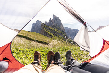 First-person view of a couple enjoying themselves from a tent on top of the mountain
