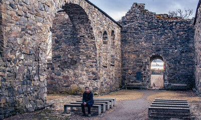 Man at the altar of old church ruins thinking about the meaning of life.
