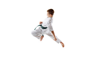 Dynamic image of teen bot, karate athlete in motion, kicking in a jump, practicing isolated on...
