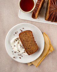 Thanksgiving Cake, cake slices topped with whipped cream and served with tea on a light cream background, with copy space. Top view. Birthday loaf cake concept. Step by step features.