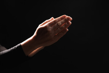 Religion. Christian woman praying on black background, closeup. Space for text