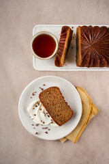 Thanksgiving Cake, cake slices topped with whipped cream and served with tea on a light cream background, with copy space. Top view. Birthday loaf cake concept. Step by step features.