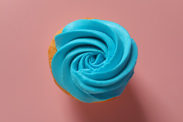 Delicious cupcake with bright cream on pink background, top view