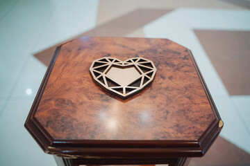 A wood heart rests on a wood table, showcasing symmetry and natural beauty