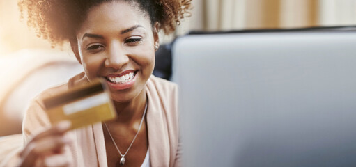 Online shopping, laptop and black woman with credit card on sofa for payment, banking or home...