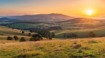 Obraz premium A panoramic view of the sun rising over rolling hills, rural tranquility at dawn