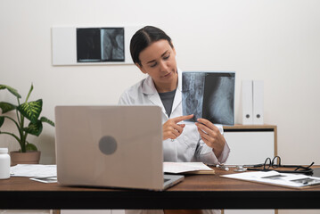 Remote Patient Consultation: doctor uses a laptop to showcase X-ray films, providing explanations...