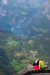 Naklejka premium Pareja de turistas y paisaje con cruceros en el fiordo de Geiranger