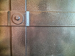 Forged rivet on a metal door or wall. Background, texture. Close-Up of a Forged Rivet Securing...