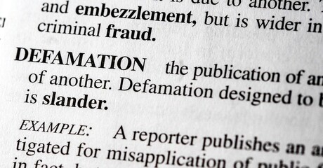 close up photo of the words defamation