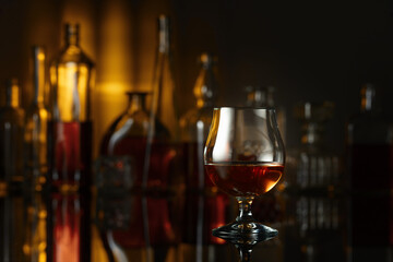  Snifter of brandy on a black table in bar.