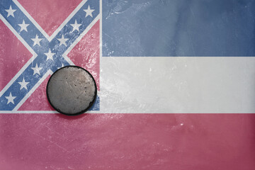 old hockey puck is on the ice with national flag of mississippi state.