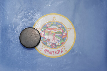 old hockey puck is on the ice with national flag of minnesota state.