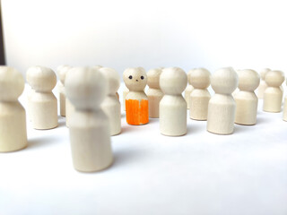 Wooden figurines with a leader and a group with partial focus. The concept of distinguishing a...